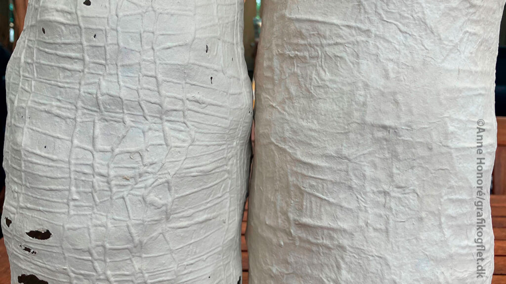 Nærbillede af to beholdere i megastrik beklædt med papirler